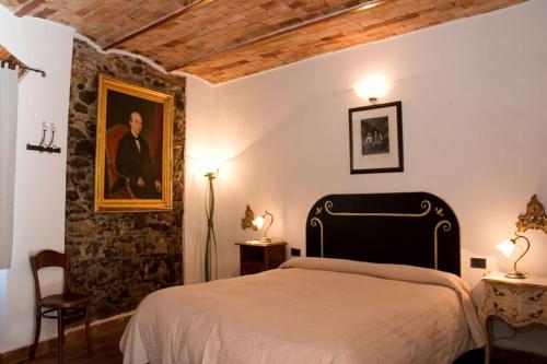 een slaapkamer met een bed en een schilderij aan de muur bij Vecchia Locanda in Sarzana