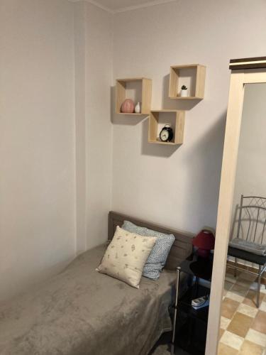 a bedroom with a bed with shelves on the wall at Bazsalikom-Apartman in Mezőkövesd
