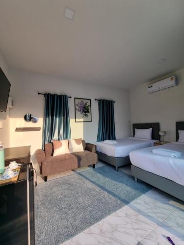 a hotel room with two beds and a couch at Charlee Khaoyai in Mu Si