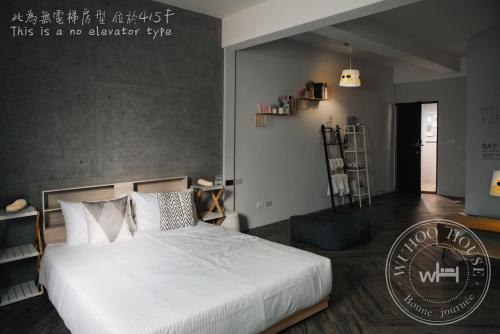 a bedroom with a large white bed in a room at Wuhoo House in Kaohsiung