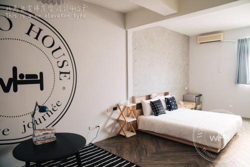 a bedroom with a bed and a sign on the wall at Wuhoo House in Kaohsiung