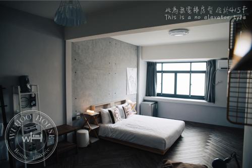 a bedroom with a bed and a window at Wuhoo House in Kaohsiung
