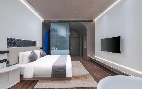 a bedroom with a large bed and a flat screen tv at R ROYALSS HOTEL Beijing Tongzhou Universal Resort Store in Tongzhou