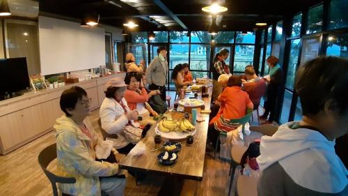 um grupo de pessoas sentadas em mesas em um restaurante em Sunny House I em Guilin