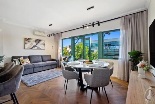 a living room with a table and chairs and a couch at Cosy Apt in Subiaco with Free Parking in Perth