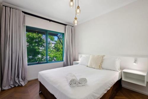 a bedroom with a large white bed with a window at Cosy Apt in Subiaco with Free Parking in Perth