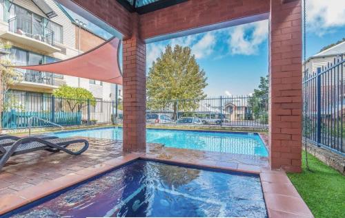 a swimming pool in front of a building at Cosy Apt in Subiaco with Free Parking in Perth
