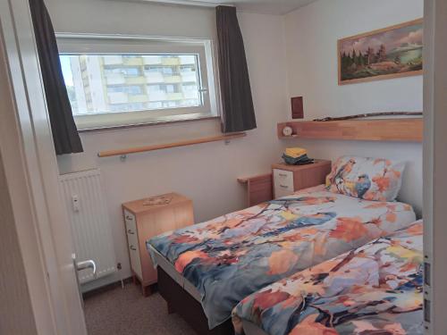 una piccola camera da letto con un letto e una finestra di Wohnung 416, Am Kurpark 3, 38700 Braunlage a Braunlage