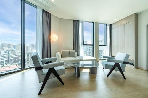a living room with a table and two chairs at Jeju Bolton Hotel in Jeju