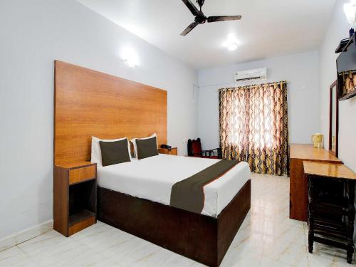 um quarto com uma cama grande e uma secretária em Collection O Maizons Lakeview Resort em Arpora