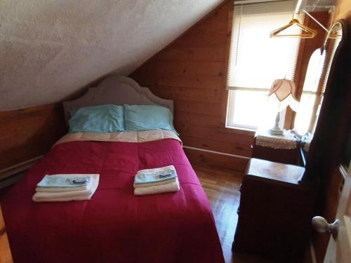 a bedroom with a bed with two towels on it at Oldest Town of Cape Cod In The Historic District in Sandwich