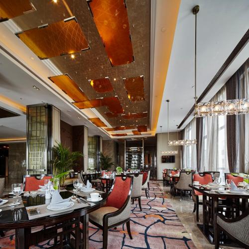 a restaurant with tables and chairs in a room at Wanda Realm Hotel Dongying in Dongying