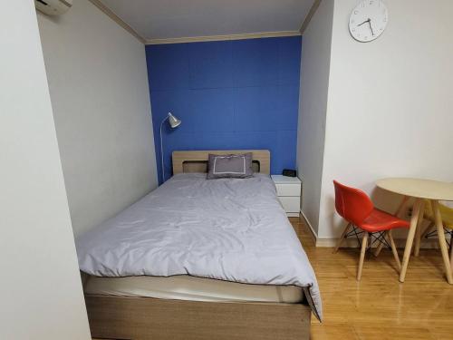 a bed in a room with a table and a chair at Changdong Property in Seoul