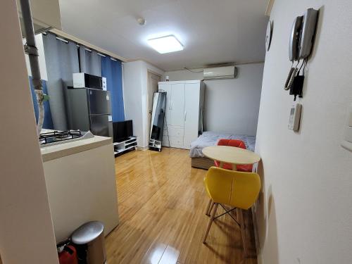 a small room with a table and a yellow chair at Changdong Property in Seoul