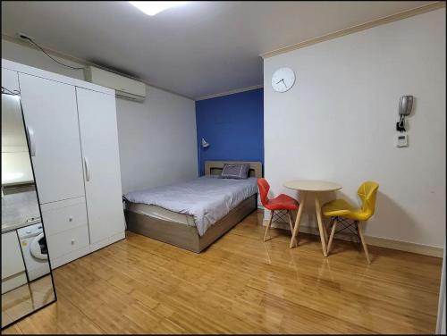 a bedroom with a bed and a table and two chairs at Changdong Property in Seoul