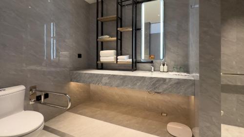 a bathroom with a toilet and a sink and a mirror at EVEN Hotel Yinchuan Yuehai by IHG in Yinchuan