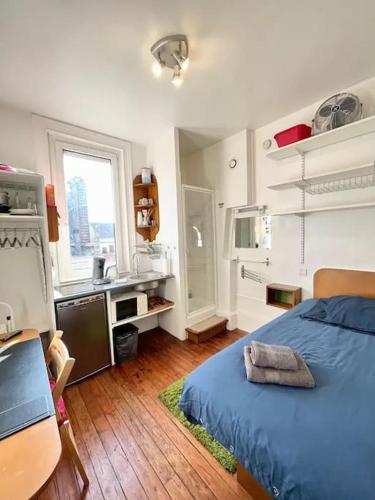 une chambre avec un lit bleu et une cuisine dans l'établissement Studette Vesle 1, à Reims