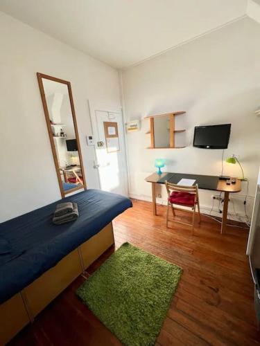 - une chambre avec un lit et un bureau avec un miroir dans l'établissement Studette Vesle 1, à Reims