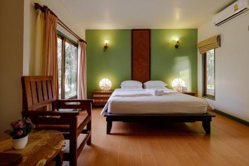 a bedroom with a large bed with green walls at The Bay Samui in Choeng Mon Beach
