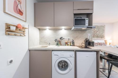 une cuisine avec une machine à laver et un évier dans l'établissement Le Bonlieu 3 - Joli studio avec balcon en plein coeur de la ville, à Annecy