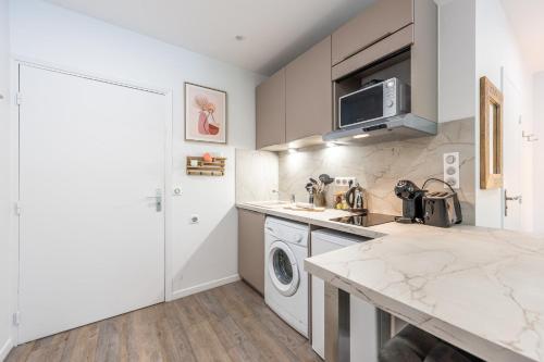 une cuisine avec un évier et une machine à laver dans l'établissement Le Bonlieu 3 - Joli studio avec balcon en plein coeur de la ville, à Annecy