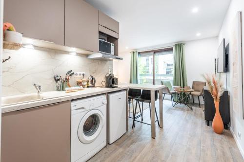 une cuisine avec un évier et une machine à laver dans l'établissement Le Bonlieu 3 - Joli studio avec balcon en plein coeur de la ville, à Annecy
