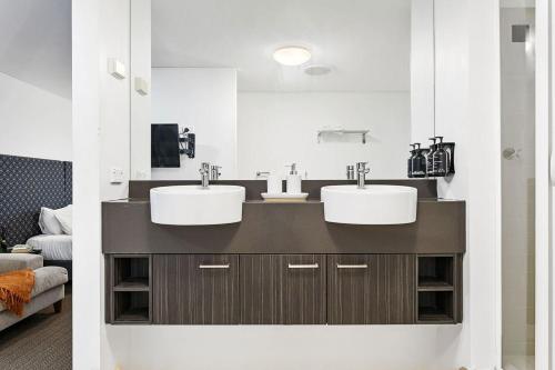 a bathroom with two sinks and a large mirror at Large Luxe Penthouse fully equipped Perth CBD in Perth