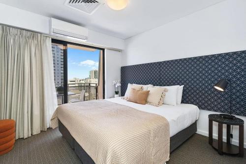 a bedroom with a large bed and a large window at Large Luxe Penthouse fully equipped Perth CBD in Perth