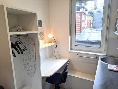 une petite cuisine avec un évier et une fenêtre dans l'établissement Studette Vesle 4, à Reims