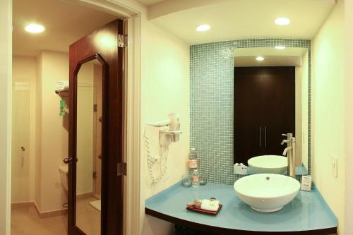 W łazience znajduje się umywalka, toaleta i lustro. w obiekcie Fiesta Inn Xalapa w mieście Xalapa