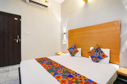 a bedroom with a bed with a wooden headboard at FabHotel The Bell in Bhilai