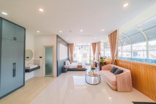 大叻的住宿－Quy Tai Premium Hotel，客厅配有沙发和桌子