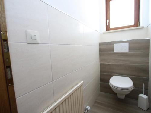 a small bathroom with a toilet and a window at Chalet in Sankt Johann near Ski Lift in Wagrain