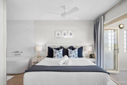 1 dormitorio blanco con 1 cama grande y bañera en Luxurious Beachfront Penthouse, en Coolum Beach