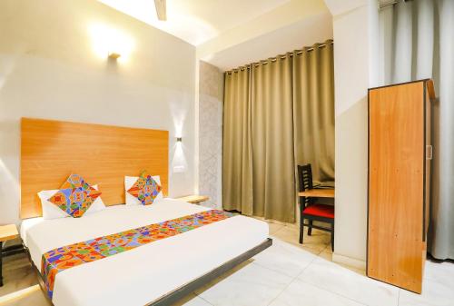 a hotel room with a bed and a desk at FabHotel The Bell in Bhilai