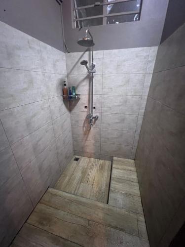 a bathroom with a shower with a wooden floor at Albion Beachfront Villa in Albion