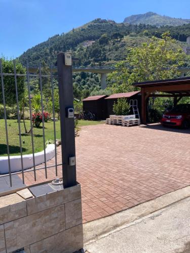 a brick driveway with a fence and a pavilion at Villa maglio in Altofonte