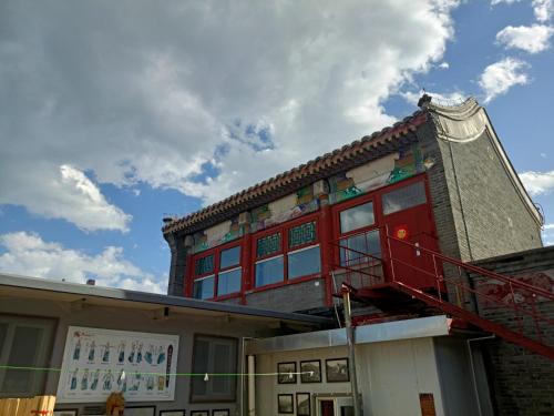 a building with a red balcony on the side of it at 南金民宿 in Qinhuangdao