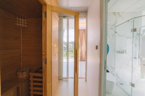 a bathroom with a walk in shower and a toilet at Quy Tai Premium Hotel in Da Lat