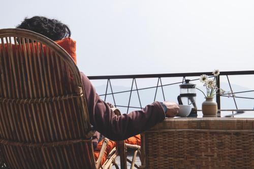 a person sitting in a chair at a table at Les Terrasses Himalayan Resort in Charikot