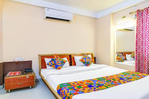 1 dormitorio con 2 camas y espejo en FabHotel Oasis, en Mātigara