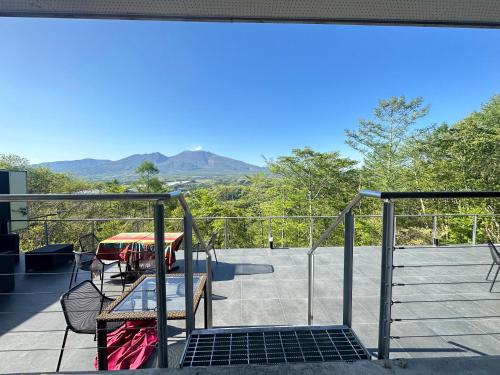 a balcony with a table and a view of mountains at Karuizawa Tennku Hotel & Resort in Karuizawa