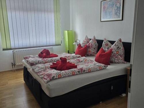 Una cama con almohadas rojas en una habitación. en Heidel Comfortable holiday residence, en Solingen