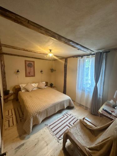 a bedroom with a bed and a large window at Hanul Bărăției in Cîmpulung