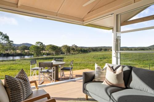 a screened porch with a couch and a table at Alkira Cottage in Ballandean