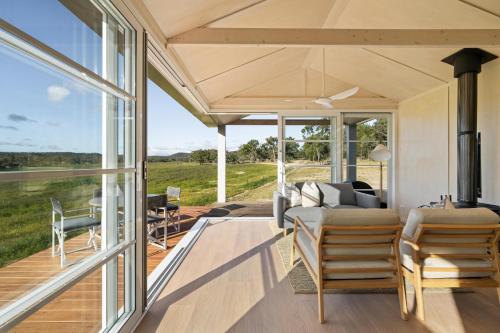 a living room with a view of the countryside through glass doors at Alkira Cottage in Ballandean