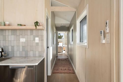 a hallway leading to a kitchen with a counter and a hallway sidx sidx at Alkira Cottage in Ballandean