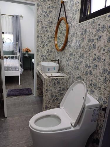 a bathroom with a toilet and a sink and a mirror at Zoom Garden Home in Nonthaburi