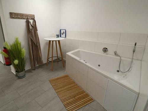 Baño blanco con bañera y mesa en Sea eagle in the Molenhuus, en Kappeln