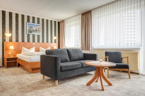 Hotel Wilna في إرفورت: غرفة في الفندق مع أريكة وسرير